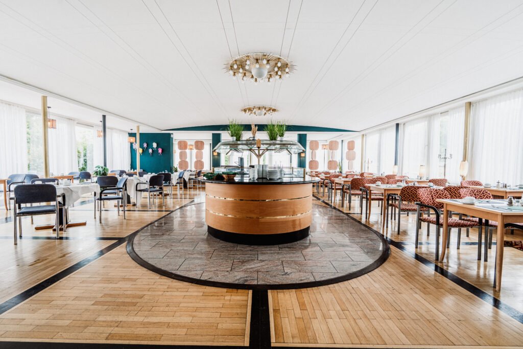 Speisesaal mit rundem Buffet und eingedeckten Tischen im Hotel Schwarzwald in Freudenstadt