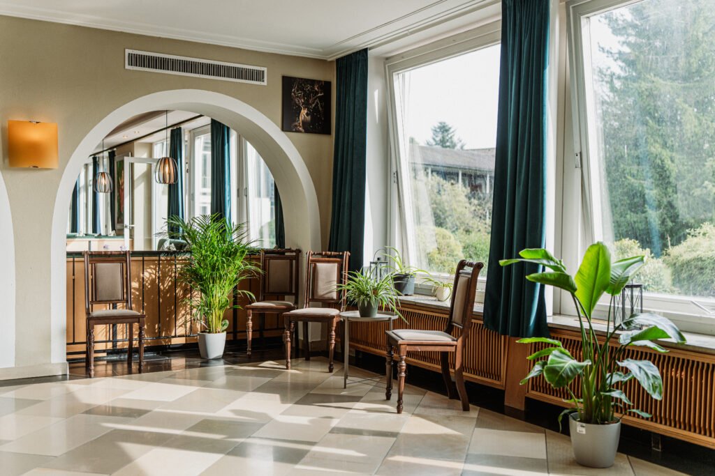 Heller Aufenthaltsbereich mit Rundbogen und Blick ins Grüne im Hotel Schwarzwald in Freudenstadt