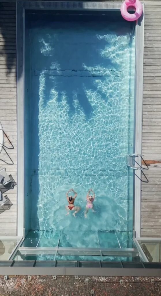 Pool von oben mit zwei Schwimmenden im Sommer – Videostill aus dem Sommerdreh, Seehotel Wiesler