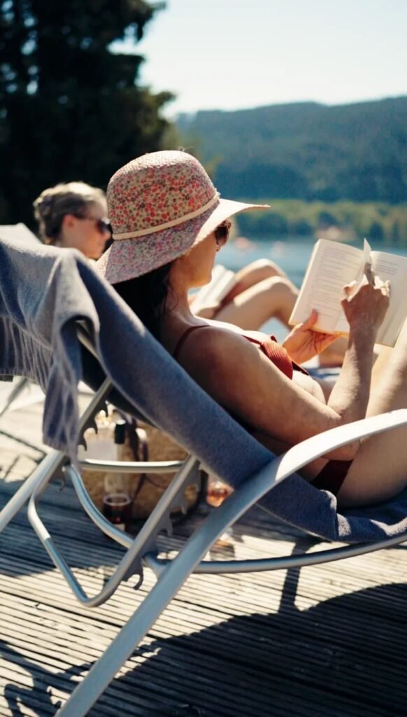 Zwei Frauen lesen auf Sonnenliegen am See – Videostill aus dem Sommerdreh, Seehotel Wiesler